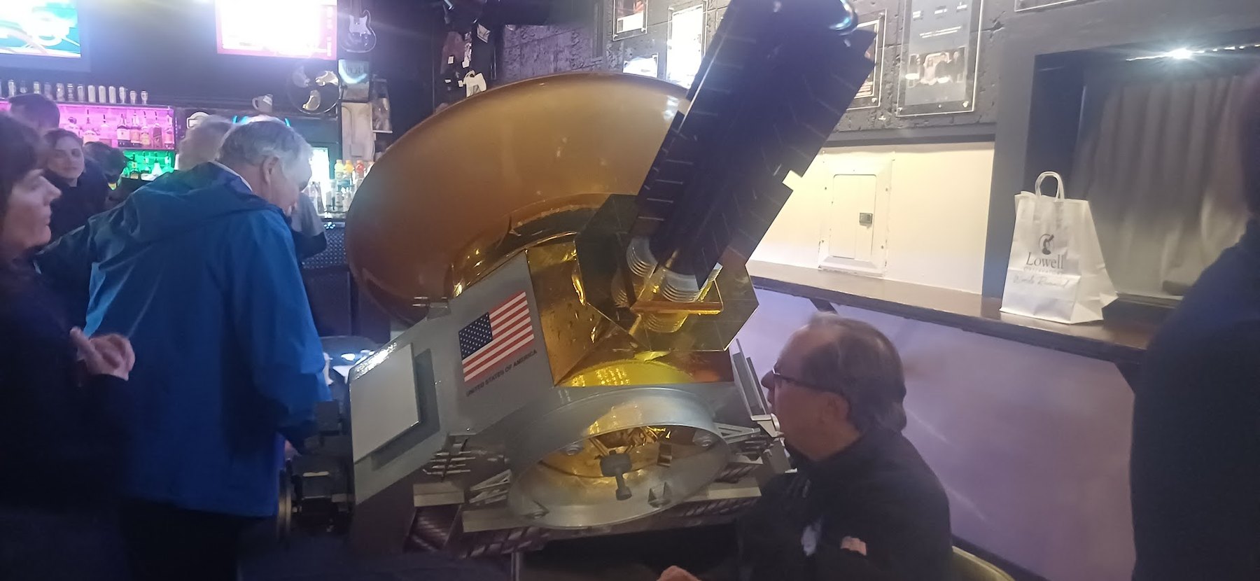 Lowell Observatory outreach display with spacecraft model and astronomy audience